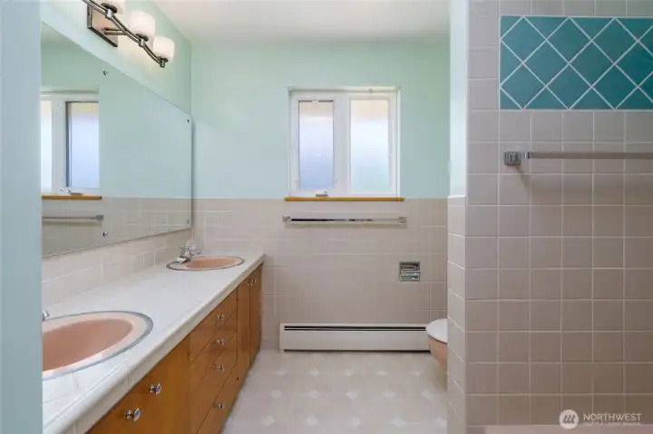 Cute, full bath off the hallway reflects the charactor of days gone by.  Double sinks, abundant cabinetry and tiled bath tub.