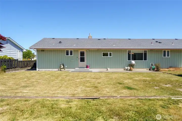 View of the back of the home with patio off the laundry room back door.