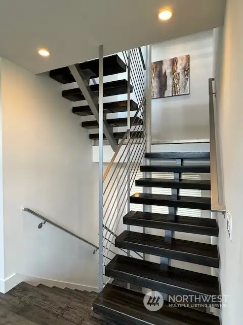 Beautiful floating wood stairs lead to the upper level and rooftop deck.