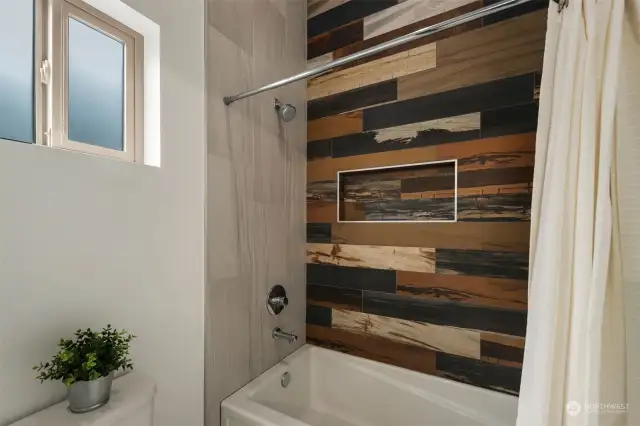 Upper level bathroom features a separate toilet/shower room with designer tub-to-ceiling tile surround and a radiant wall heater/towel warmer.