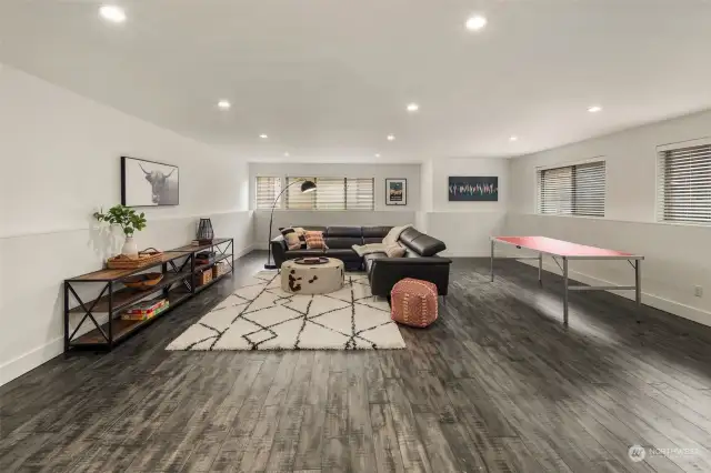 Lower level family room is large enough for a separate game table and furniture in addition to a large sectional/TV area. Tall ceilings, lots of windows and radiant engineered wood floors make this a place you'll love to spend time in!