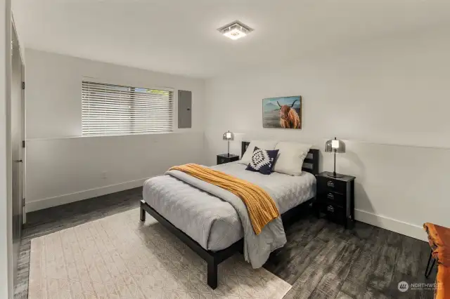 Large lower level bedroom with egress window, radiant heated engineered floors and closet with light.