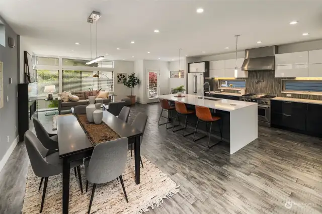 This view shows how connected the home is, while still creating separate areas for cooking, eating and relaxing. Perfect space for those who love to entertain! Beautiful radiant heated engineered hardwood floors flow throughout the home.