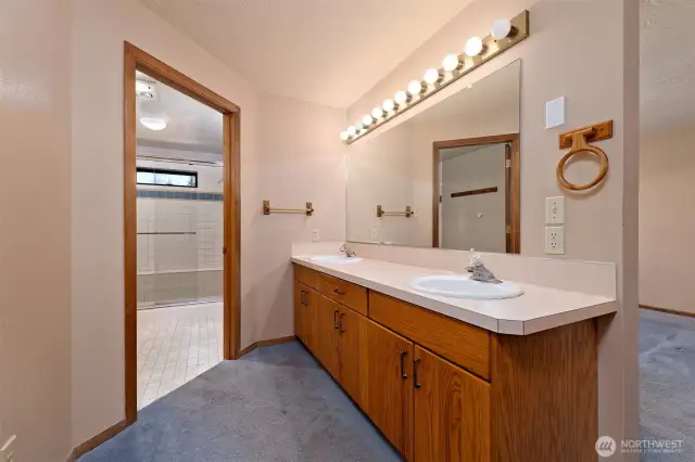 Primary bathroom with 2 sinks, a large step-in shower, and a huge walk-in closet.