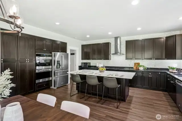 Large chef’s island kitchen with high-end appliances & designer tile & walk-in pantry