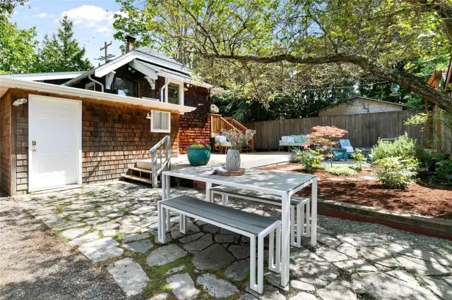 The no-lawn-maintenance park-like backyard will turn you into the perfect host. An all-seasons wonderland with backyard BBQs all summer and toasty s’mores all winter! Note that the door leads to the lower-level primary bedroom.
