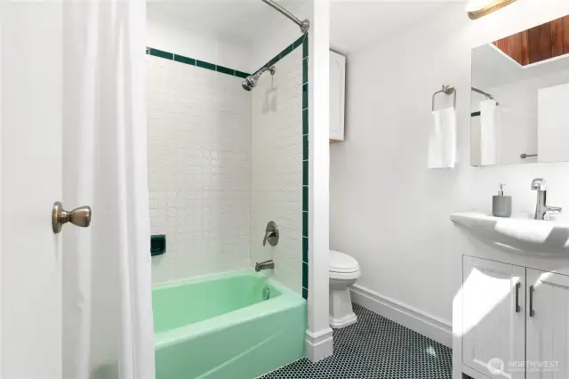 The main level full bath features tile flooring that is both cute and heated!