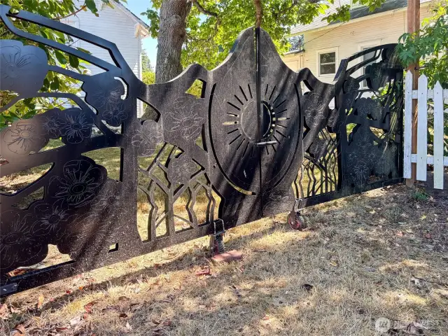 Custom designed metal gate at the entrance to the barn and side yard.