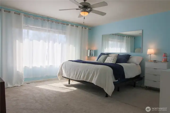 Spacious primary bedroom, bathed in western light