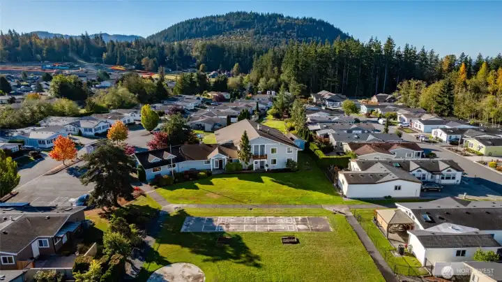 Among the amenities at Little Mountain Estates are shuffleboard and horse shoe pits.  The clubhouse is at center, and includes a heated, indoor pool, a library, a TV/gathering room, kitchen, and event space.  Little Mountain itself is at the back of this photo.