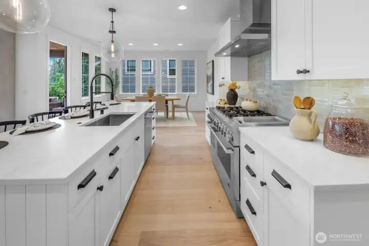 Bright and open kitchen with seamless connection to the dining and living areas. Oversized windows and designer finishes create a space both beautiful and practical.