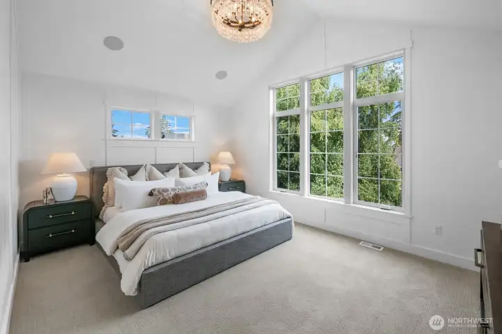 Vaulted primary suite with oversized windows, designer chandelier, and serene treetop outlooks. A private retreat filled with natural light.