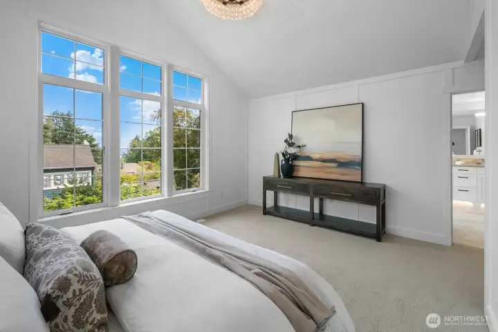 Panoramic windows in the primary suite bring the outdoors in, creating a serene and light-filled sanctuary.