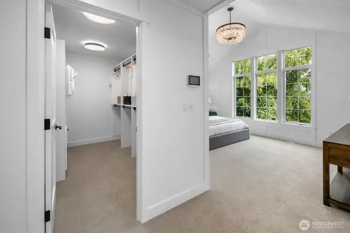 Expansive walk-in closet with custom built-ins and abundant storage, seamlessly connected to the vaulted primary suite for everyday convenience.