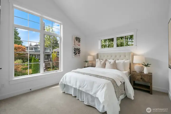 Bright secondary bedroom with vaulted ceilings, oversized windows, and flexible layout for guests, office, or family use.