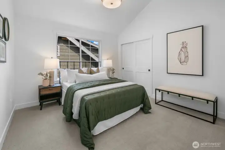 Generous guest bedroom with vaulted ceiling, full closet, and large window for natural light. Comfortably appointed and versatile.