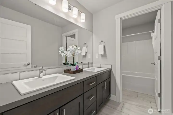 Full bathroom with double vanity upstairs adjacent to bedrooms.