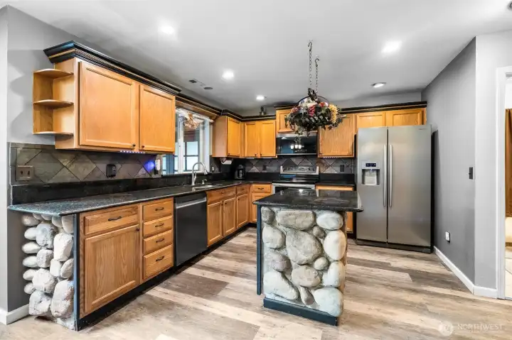 Warm wood cabinetry and stone accents give the kitchen a comfortable feel