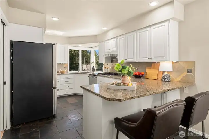 Chef’s kitchen overlooking lush greenery. Peninsula island with convenient eating bar.