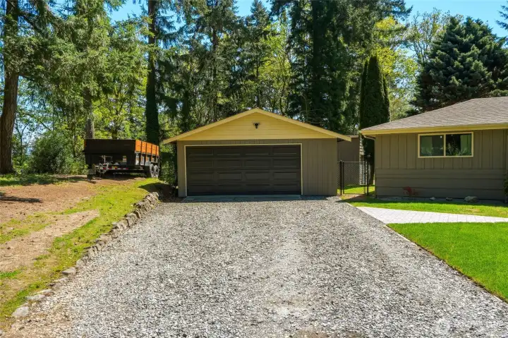 Oversized detached garage with extended driveway, perfect for storage, projects, and additional parking on acreage property.