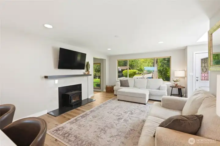 Inviting living room featuring wood-burning fireplace, abundant natural light, and connection to outdoor views.