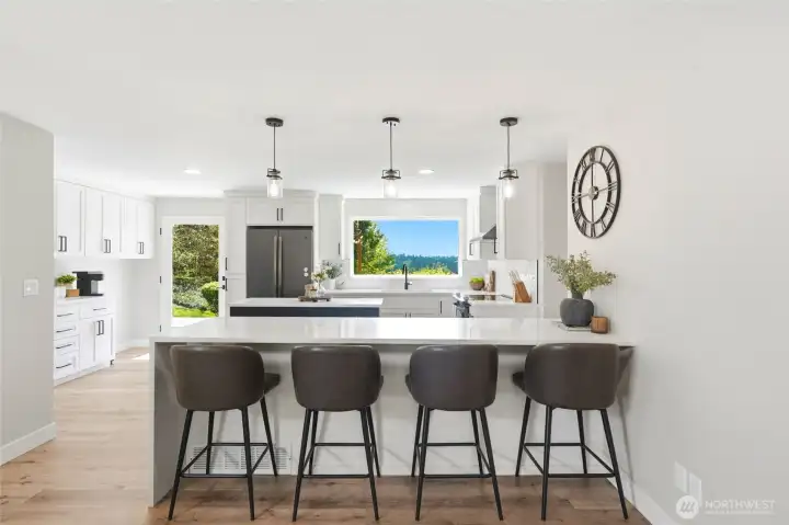 Updated kitchen with large island, bar seating, and panoramic views of Mt. Rainier through expansive windows.