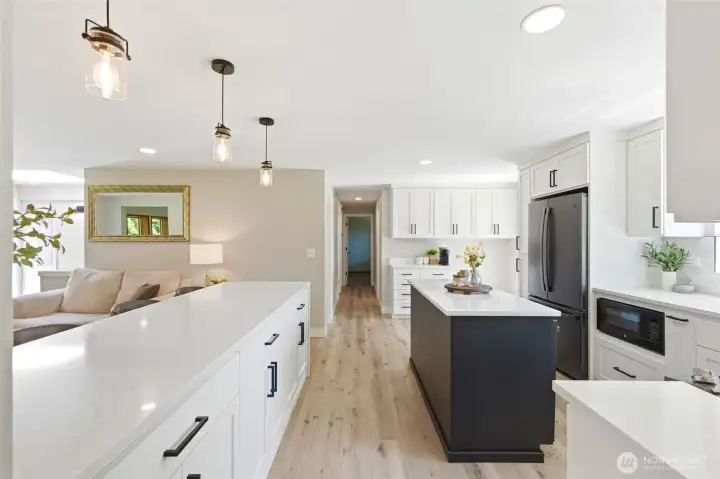 Fully renovated kitchen with modern finishes, ample counter space, and open flow into dining and living areas.