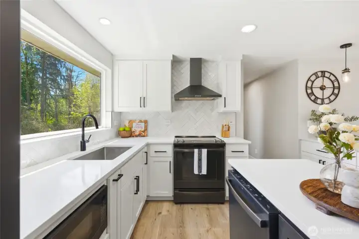 Chef’s kitchen with sleek cabinetry, quartz-style counters, and bright natural lighting throughout.