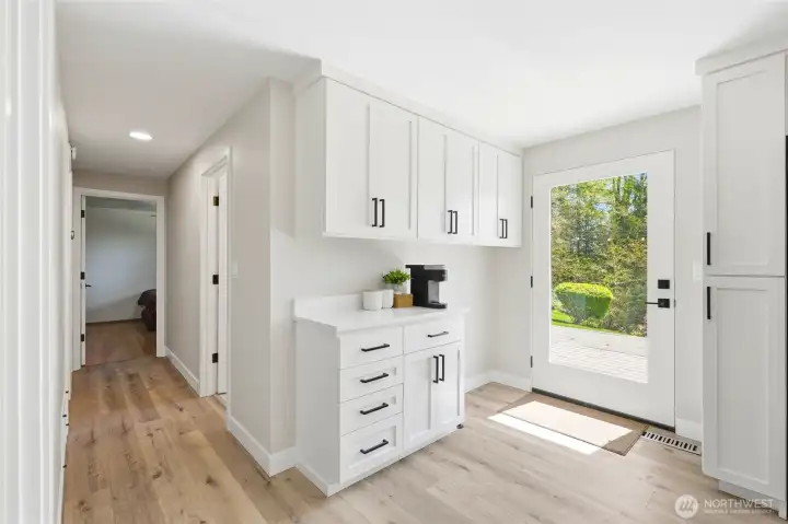 Clean and bright utility or secondary kitchen space with additional storage and workspace.