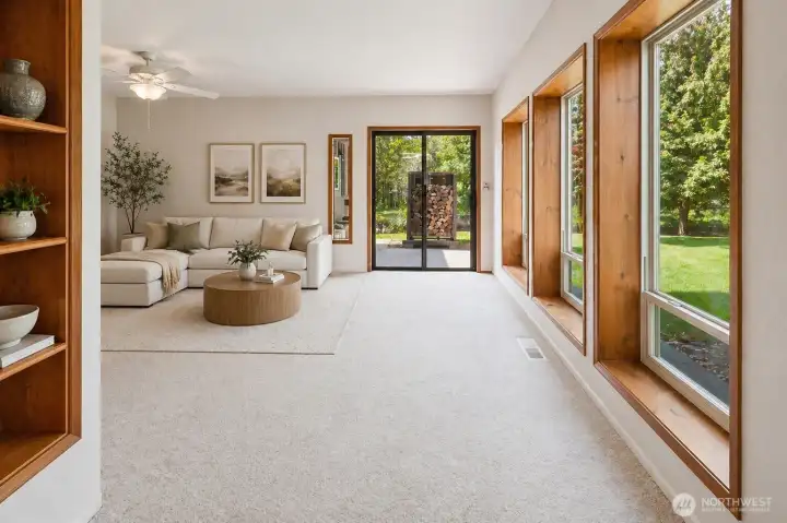 Sun-filled living space with large picture windows, showcasing peaceful backyard views and natural surroundings.