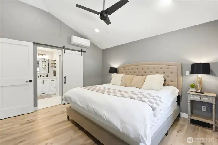 Spacious primary bedroom with vaulted ceilings, modern finishes, and peaceful views of surrounding nature.