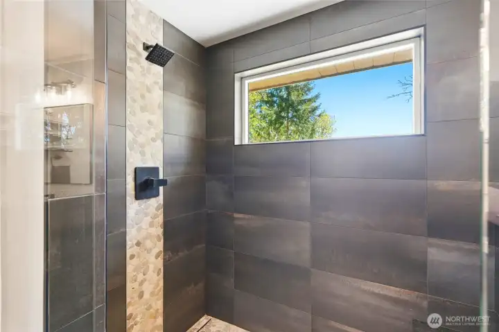 Custom tiled walk-in shower with sleek finishes and natural light, creating a spa-like bathroom experience.