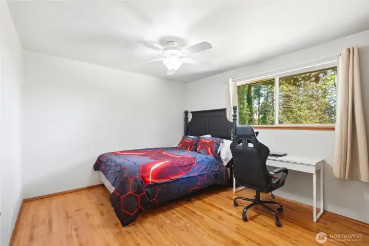 Comfortable bedroom with large window, natural light, and peaceful views of the surrounding property.