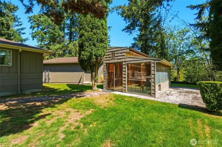 Private backyard with outbuildings and open green space, ideal for hobbies, storage, or outdoor living