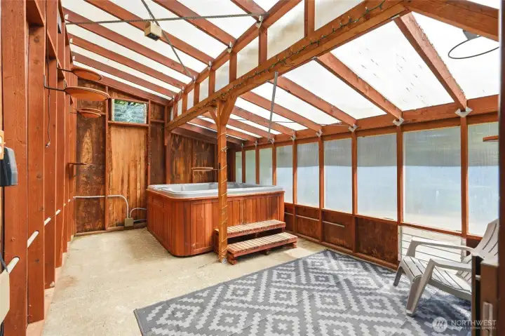 Year-round enclosed hot tub room with wood accents and abundant natural light for relaxing in any season.