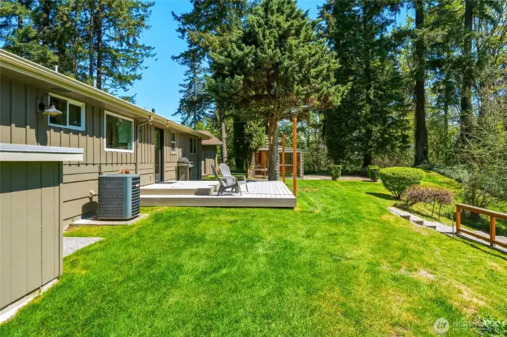 Expansive backyard lawn with mature trees and usable acreage, perfect for entertaining or recreation.