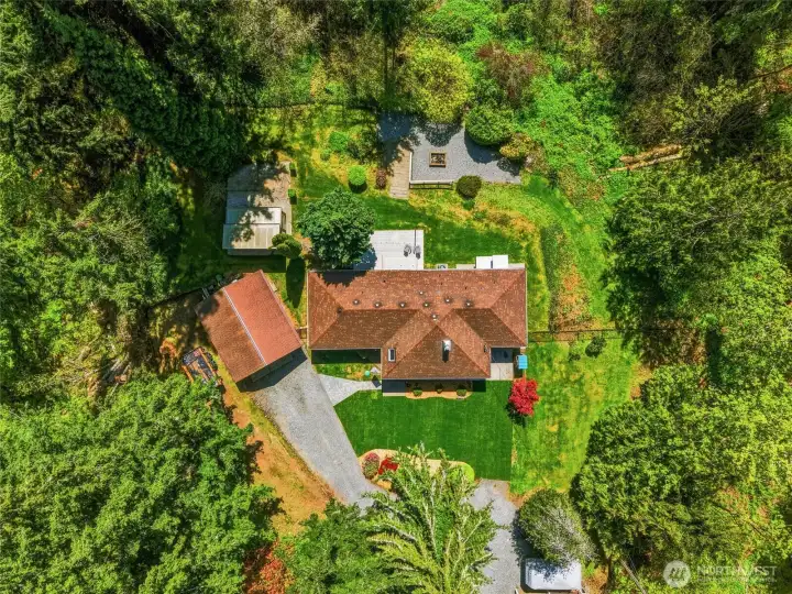 Bird’s-eye view of the property layout showing home, outbuildings, driveway, and expansive usable land.