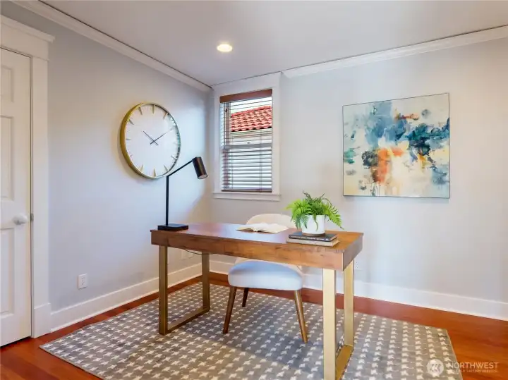 Main floor office with crown molding, Brazilian hardwood floors, and natural light — a rare and versatile space perfect for working from home.