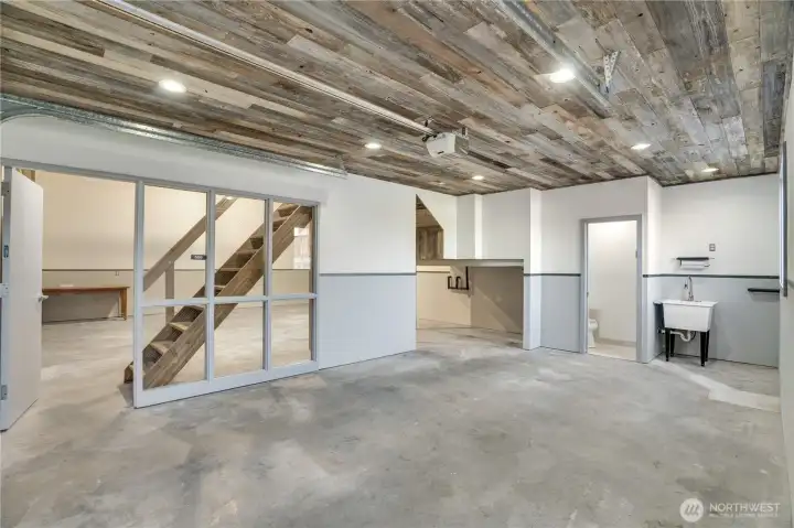 Reclaimed wood ceiling. Steel and glass partition. Polished concrete. This is what a master builder does with a garage.