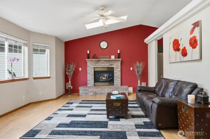 The wood burning fireplace, the skylights, ceiling fan and bay window are all parts of this wonderful living room.