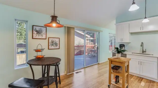 A look at the kitchen featuring a large sliding glass door leading to the entertainment sized deck, offering easy access to fresh air and outdoor living.