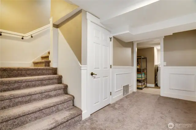 Welcome to the lower floor, where attention to detail is evident throughout. To the left you will find the mechanical room, a new heat pump with air conditioning installed 2024 and the water heater. Straight ahead is the laundry room, with additional storage. To the right is another closet, and the stairway leading to garage is also located in this hallway.