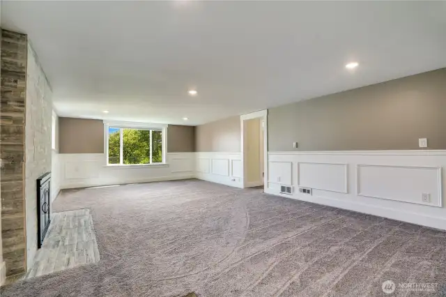 The stone surround on the fireplace is classy and the details from the upstairs spaces flow through this level too!