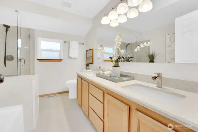 Primary en-suite features upgraded fixtures, stone slab countertops, and lots of natural light.