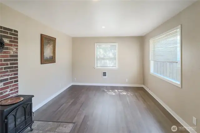 Light-filled living room with updated flooring creates a welcoming space to relax or gather.