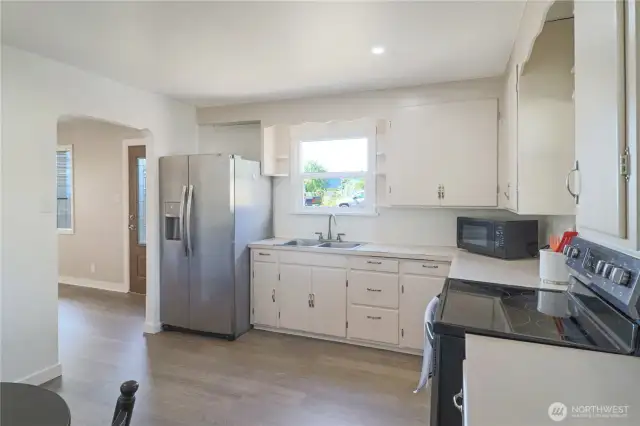 Second kitchen view showcases abundant cabinet space, stainless refrigerator and smooth top range - easy flow for daily living.