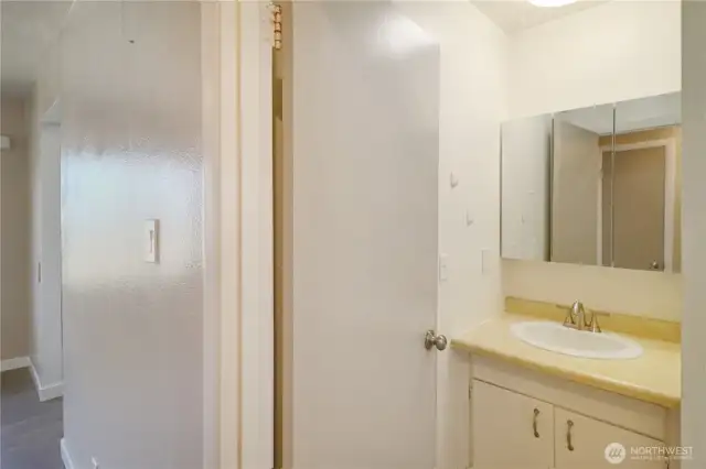 Crisp and clean bathroom with excellent lighting and a storage-friendly vanity.