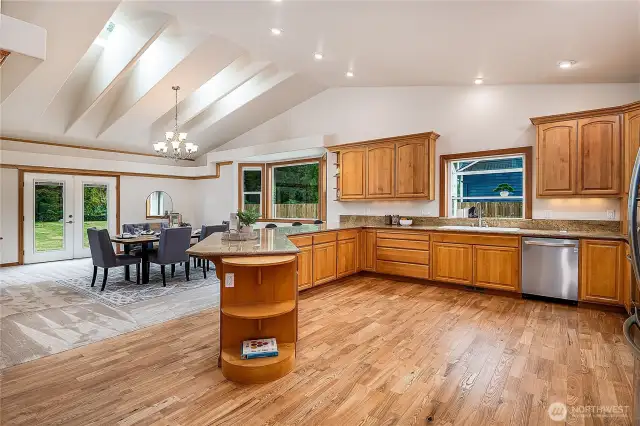 Look at this massive kitchen! The original hardwood floors have been refinished and are gorgeous. Skylights and lofty cathedral ceilings bathe the space with light.