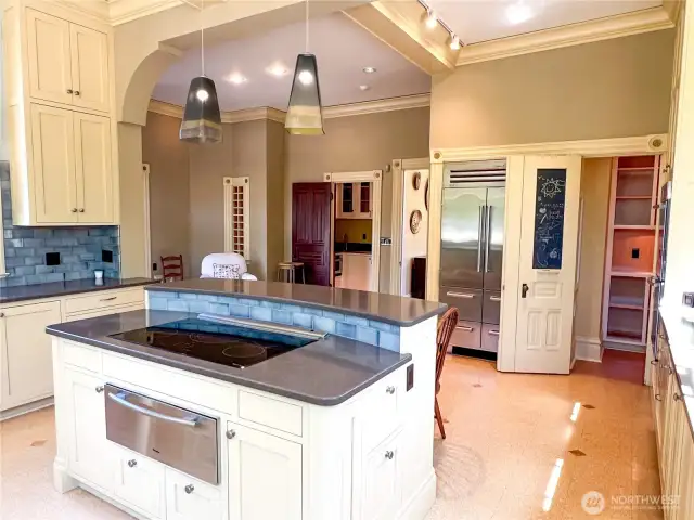 Electric cooktop and second pantry to the right of the refrigerator.