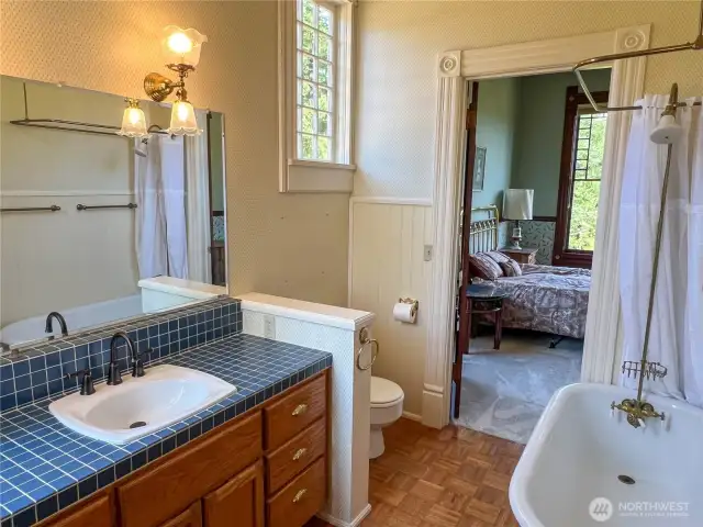 Full bath with claw foot tub/shower is situated conveniently between two rooms.